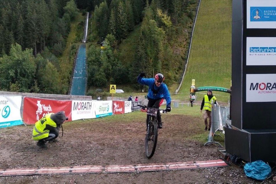 The penultimate rider crosses the finish line